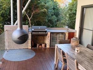 a outdoor patio with a grill and a table with a table at Hilltop Getaway in Ocean View