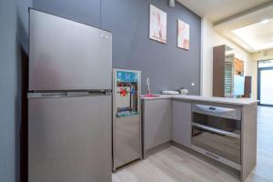 - une cuisine avec un réfrigérateur en acier inoxydable à côté d'un comptoir dans l'établissement 橙居 台南安平包棟民宿 依人數開放房型 麻將 唱歌 泡湯屋 加大雙人床, à Anping