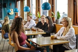a group of people sitting at tables in a restaurant at Loft - HI Eco Hostel in Reykjavík