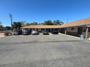 a parking lot in front of a building with cars parked at Studio with a kitchenette in an updated motel in Basse-Terre