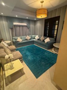 a living room with a couch and a blue rug at Alzahra Jaccuzi apt in Quai