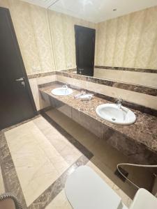 a bathroom with two sinks and a toilet at Alzahra Jaccuzi apt in Quai +10 photos
