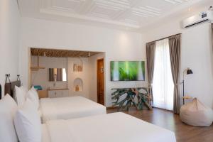 Un dormitorio blanco con dos camas y una ventana. en Statler Private Beach Villa Mandalika, en Kuta Lombok
