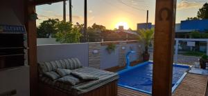 a couch on a balcony with a view of a pool at Casa aconchegante em nova tramandai centro in Tramandaí