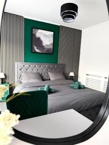 a bedroom with a bed with green walls and a mirror at D&D Emerald House Anfield in Liverpool