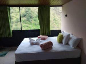 a bedroom with a bed with towels and a window at Ella Deck Villa in Ella