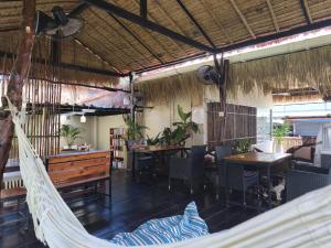 eine Hängematte in einem Raum mit Tischen und Stühlen in der Unterkunft JOP in Ko Chang