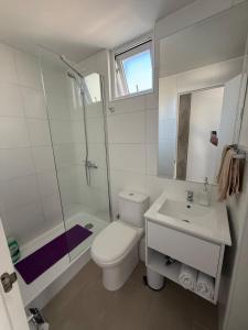 a bathroom with a toilet and a sink and a shower at Apartamento Centro con Estacionamiento in Concepción