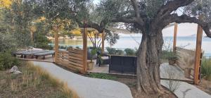a gazebo with benches next to a tree at Actaea Villa in Alonnisos Old Town +40 photos
