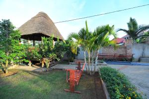 a hut with a table and chairs in a yard at Guadalupe house in Masaka