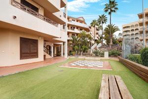 Blick auf einen Hof mit einer Bank und Gras in der Unterkunft Oasis del Sur in San Miguel de Abona
