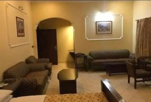ラホールにあるHotel Indusのリビングルーム(ソファ、椅子付)