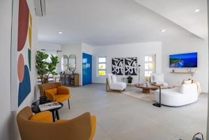 苏莎亚Sosua Ocean Village Villa 24的大型客厅配有黄色和白色家具