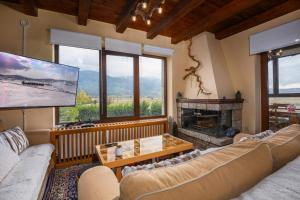 a living room with two couches and a tv at Chalet Panorama -Three Level Escape in Parnassos in Arachova