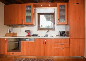 a kitchen with wooden cabinets and a sink and a window at Chalet Panorama -Three Level Escape in Parnassos in Arachova
