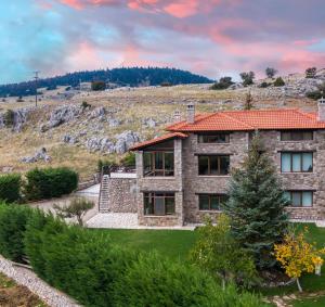 a stone house with a red roof at Chalet Panorama -Three Level Escape in Parnassos in Arachova