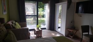 a living room with a couch and a sliding glass door at B&B 't Goedhof in Maaseik