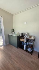 a room with a kitchen with a counter and a table at Camellia Cottage - Pool Room in Meadowridge +7 photos