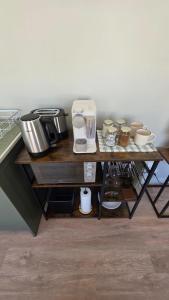 a table with a coffee maker and cups on it at Camellia Cottage - Pool Room in Constantia