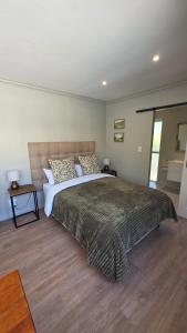a bedroom with a large bed in a room at Camellia Cottage - Pool Room in Meadowridge