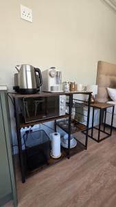 a table with pots and pans on top of it at Camellia Cottage - Pool Room in Constantia +7 photos