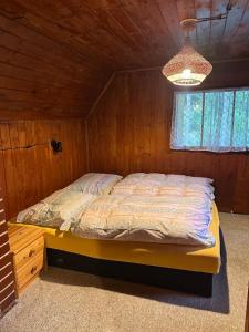 a bedroom with a bed in a wooden room at Srub pod Lysou horou in Ostravice