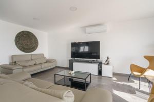 a living room with a couch and a tv at Villa Zen with sea view and private pool in Lourinhã +30 photos