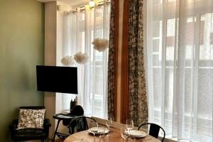 アラスにあるL'atelier Arrageois - 55m2 6 persのテーブルと大きな窓のあるダイニングルーム