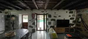 ein Wohnzimmer mit Fernseher und Tisch in der Unterkunft Jesús del Monte in Santa Brígida