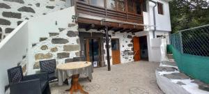 eine Terrasse mit Tisch und Stühlen und ein Gebäude in der Unterkunft Jesús del Monte in Santa Brígida