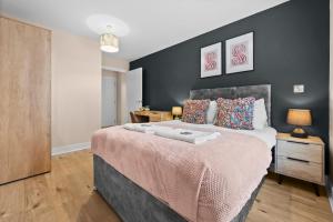 a bedroom with a large bed with a black wall at Stylish & Spacious 3BR 3Bath with Private Parking, WiFi, Smart TVs in Spon End