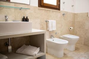 a bathroom with a white sink and a toilet at San Domenico Residence by BADIA NUOVA in Trapani