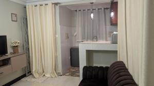 a living room with a fireplace and a kitchen with curtains at BougainVille in Fort Portal +61 photos