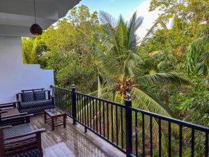 a balcony with benches and a palm tree at Sundaras Family Suites in Dambulla