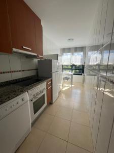 a kitchen with white appliances and a large window at Gestiona2R - Apartamento en el casco antiguo Llanisco in Llanes