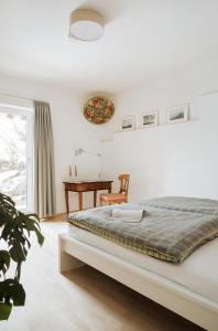 a white bedroom with a bed and a desk at Ferienwohnung Gute Laune in Berchtesgaden