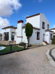 a house with a golf course in front of it at Agradable casa con piscina en la serranía. in Arriate