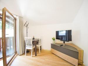 a living room with a table with a tv and a dining room at Ferienwohnung Kehlsteinblick in Berchtesgaden