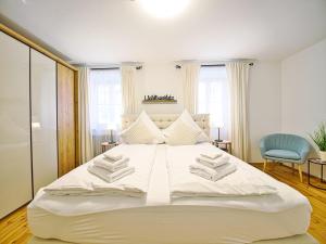 a bedroom with a large white bed with towels on it at Ferienwohnung Faes in Berchtesgaden +10 photos