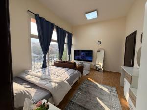 een woonkamer met een bank en een groot raam bij استديو مفروش المشرف in Baţīn +2 foto's
