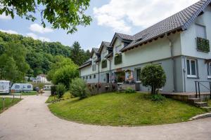a house with a grassy yard next to a driveway at Camping du Rivage in Wallendorf pont