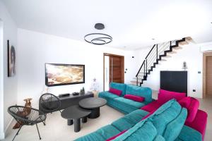 a living room with a couch and a table at SUMMER VIEW classée 5 étoiles - Magnifique Villa 10 personnes avec piscine miroir chauffée à 29 degrés, bain à remous intégré et vue mer idéalement située Chemin Summer - ST GILLES LES BAINS in Saint-Gilles les Bains