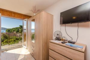 a living room with a television and a balcony at Apartments Marija in Rogoznica
