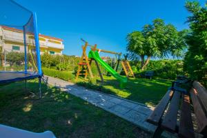 a park with a playground with a slide at Apartments Boza in Lopar