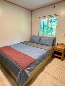 a bed in a room with a window at Chalee Guest House in Ban Khlong Mat