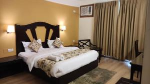 a bedroom with a large bed with white sheets and pillows at Aloha 1 & 2 BHK with Infinity Pool in Rishīkesh
