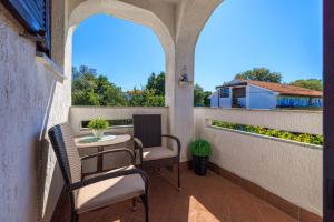 un patio con sedie e un tavolo su un balcone di Apartment Dragica a Malinska