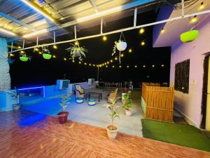 a large room with a table and plants and lights at Rv stay pushkar in Pushkar