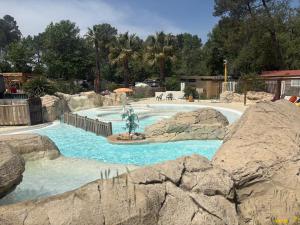 a swimming pool with a fountain in the middle at Le Coin Provençal in Nans-les-Pins