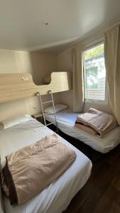 two bunk beds in a room with a window at Le Coin Provençal in Nans-les-Pins